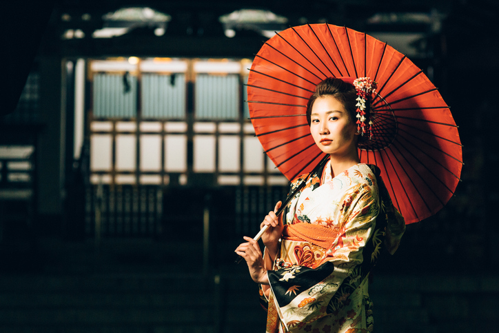 和傘を差してこちらを見ている着物を着た日本女性